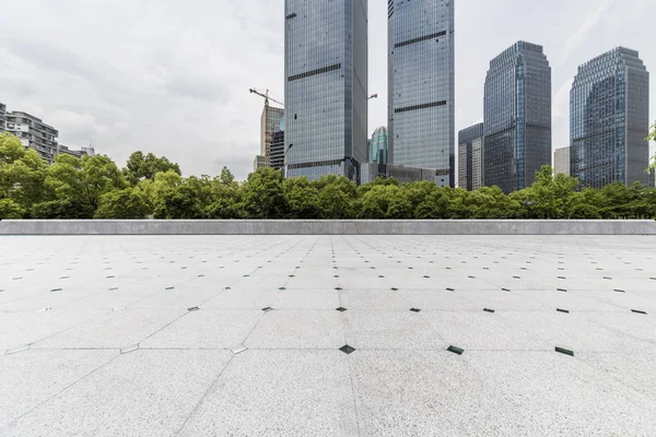 Panoramik siluet ve boş yolu, boş beton zemini olan modern iş binaları.