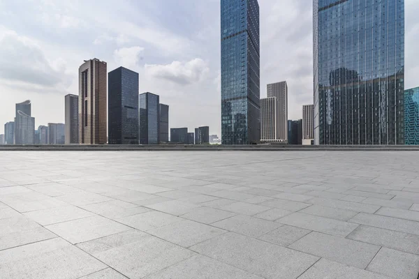Panoramik siluet ve boş yolu, boş beton zemini olan modern iş binaları.