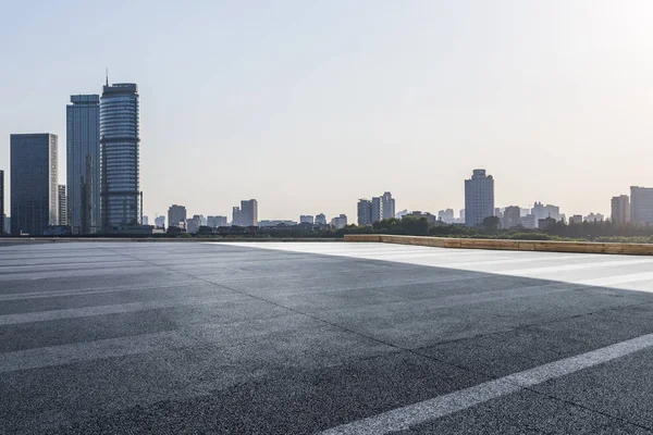 Panoramik siluet ve boş yolu, boş beton zemini olan modern iş binaları.