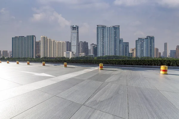 Panoramik siluet ve boş yolu, boş beton zemini olan modern iş binaları.