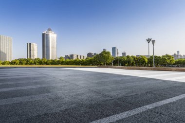 Panoramik siluet ve boş yolu, boş beton zemini olan modern iş binaları.