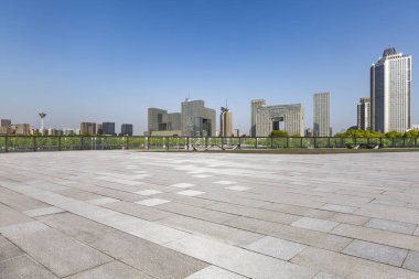 Panoramik siluet ve boş yolu, boş beton zemini olan modern iş binaları.