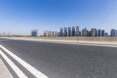 Panoramik siluet ve boş yolu, boş beton zemini olan modern iş binaları.