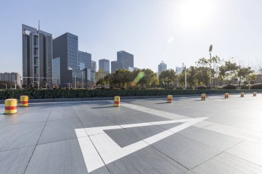 Panoramik siluet ve boş yolu, boş beton zemini olan modern iş binaları.