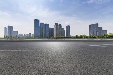 Panoramik siluet ve boş yolu, boş beton zemini olan modern iş binaları.