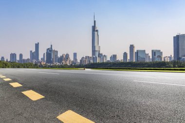 Panoramik siluet ve boş yolu, boş beton zemini olan modern iş binaları.
