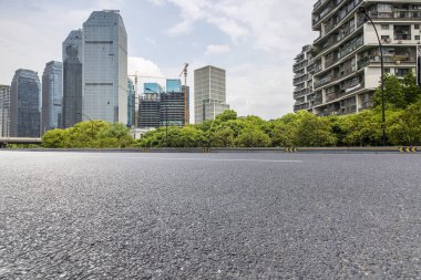 Panoramik siluet ve boş yolu, boş beton zemini olan modern iş binaları.