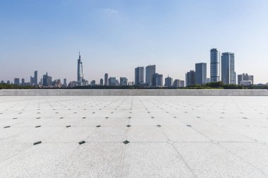 Panoramik siluet ve boş yolu, boş beton zemini olan modern iş binaları.