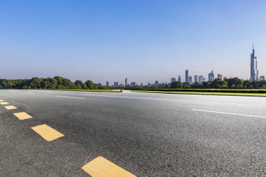 Panoramik siluet ve boş yolu, boş beton zemini olan modern iş binaları.