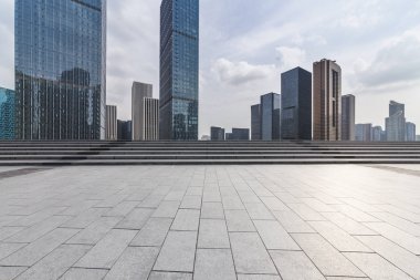 Panoramik siluet ve boş yolu, boş beton zemini olan modern iş binaları.
