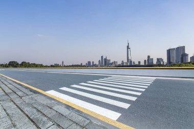 Panoramik siluet ve boş yolu, boş beton zemini olan modern iş binaları.