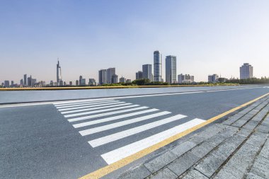 Panoramik siluet ve boş yolu, boş beton zemini olan modern iş binaları.