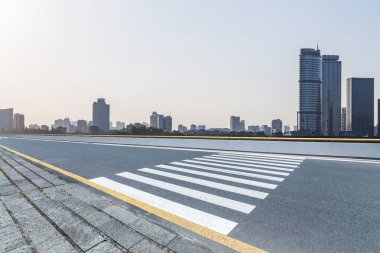Panoramik siluet ve boş yolu, boş beton zemini olan modern iş binaları.