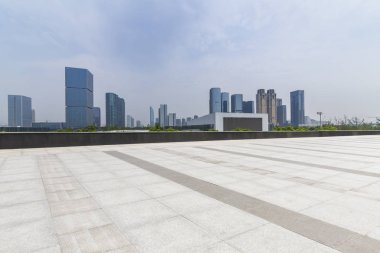 Panoramik siluet ve boş yolu, boş beton zemini olan modern iş binaları.