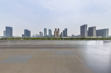 Panoramik siluet ve boş yolu, boş beton zemini olan modern iş binaları.