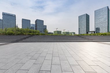 Panoramik siluet ve boş yolu, boş beton zemini olan modern iş binaları.