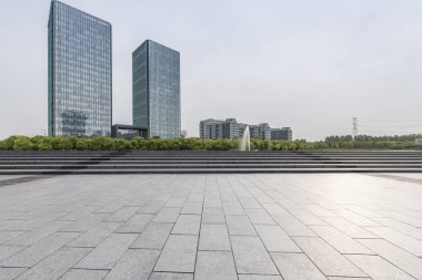 Panoramik siluet ve boş yolu, boş beton zemini olan modern iş binaları.