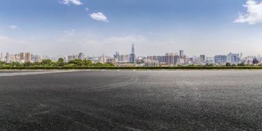 Panoramik siluet ve boş yolu, boş beton zemini olan modern iş binaları.