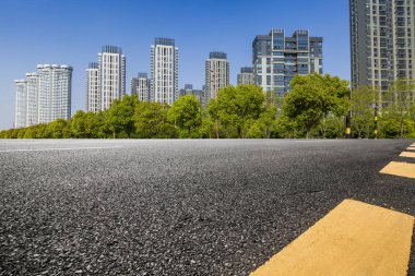 Panoramik siluet ve boş yolu, boş beton zemini olan modern iş binaları.