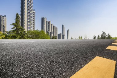 Panoramik siluet ve boş yolu, boş beton zemini olan modern iş binaları.