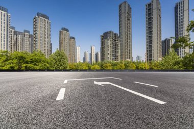 Panoramik siluet ve boş yolu, boş beton zemini olan modern iş binaları.