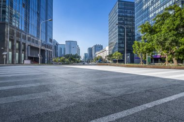 Panoramik siluet ve boş yolu, boş beton zemini olan modern iş binaları.