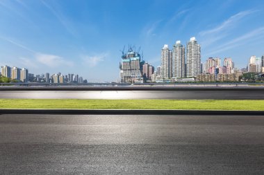 Panoramik siluet ve boş yolu, boş beton zemini olan modern iş binaları.