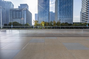 Panoramik siluet ve boş yolu, boş beton zemini olan modern iş binaları.