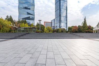 Panoramik siluet ve boş yolu, boş beton zemini olan modern iş binaları.
