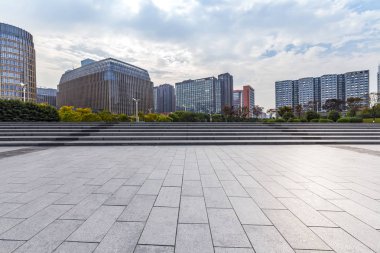 Panoramik siluet ve boş yolu, boş beton zemini olan modern iş binaları.