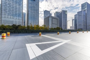 Panoramik siluet ve boş yolu, boş beton zemini olan modern iş binaları.