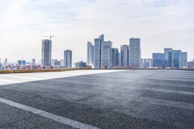 Panoramik siluet ve boş yolu, boş beton zemini olan modern iş binaları.