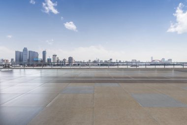 Panoramik siluet ve boş yolu, boş beton zemini olan modern iş binaları.