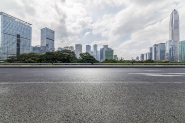 Panoramik siluet ve boş yolu, boş beton zemini olan modern iş binaları.