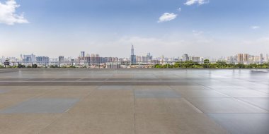 Panoramik siluet ve boş yolu, boş beton zemini olan modern iş binaları.