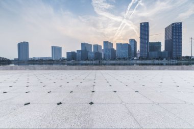 Panoramik siluet ve boş yolu, boş beton zemini olan modern iş binaları.