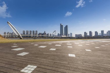 Panoramik siluet ve boş yolu, boş beton zemini olan modern iş binaları.