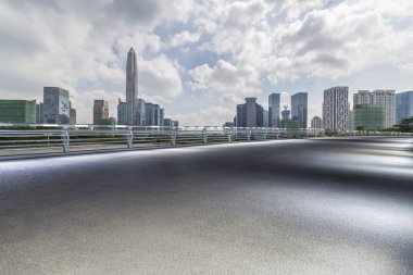 Panoramik siluet ve boş yolu, boş beton zemini olan modern iş binaları.