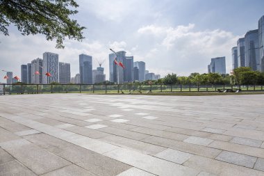 Panoramik siluet ve boş yolu, boş beton zemini olan modern iş binaları.