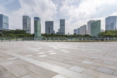 Panoramik siluet ve boş yolu, boş beton zemini olan modern iş binaları.