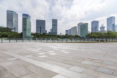 Panoramik siluet ve boş yolu, boş beton zemini olan modern iş binaları.