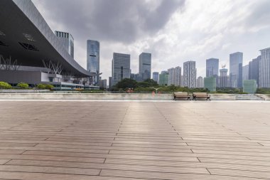 Panoramik siluet ve boş yolu, boş beton zemini olan modern iş binaları.