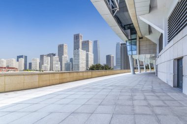 Panoramik siluet ve boş yolu, boş beton zemini olan modern iş binaları.