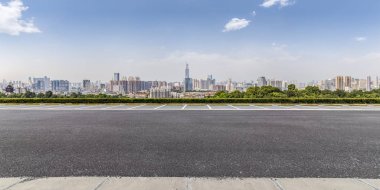 Panoramik siluet ve boş yolu, boş beton zemini olan modern iş binaları.