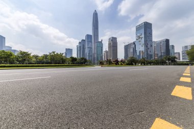 Panoramik siluet ve boş yolu, boş beton zemini olan modern iş binaları.