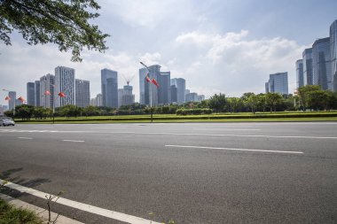 Panoramik siluet ve boş yolu, boş beton zemini olan modern iş binaları.