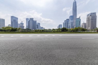 Panoramik siluet ve boş yolu, boş beton zemini olan modern iş binaları.