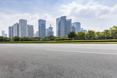Panoramik siluet ve boş yolu, boş beton zemini olan modern iş binaları.