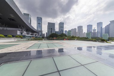 Panoramik siluet ve boş yolu, boş beton zemini olan modern iş binaları.