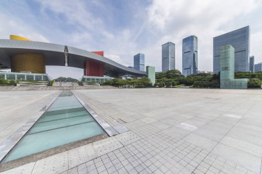 Panoramik siluet ve boş yolu, boş beton zemini olan modern iş binaları.